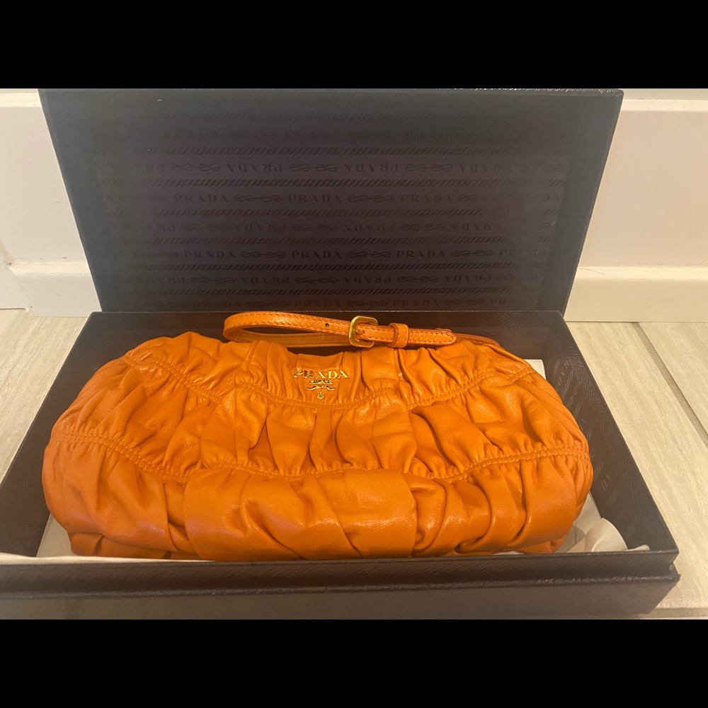Prada rushed leather mango/orange clutch.